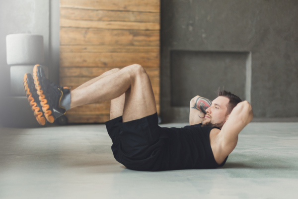 Young man fitness workout, sit-up crunches for abs